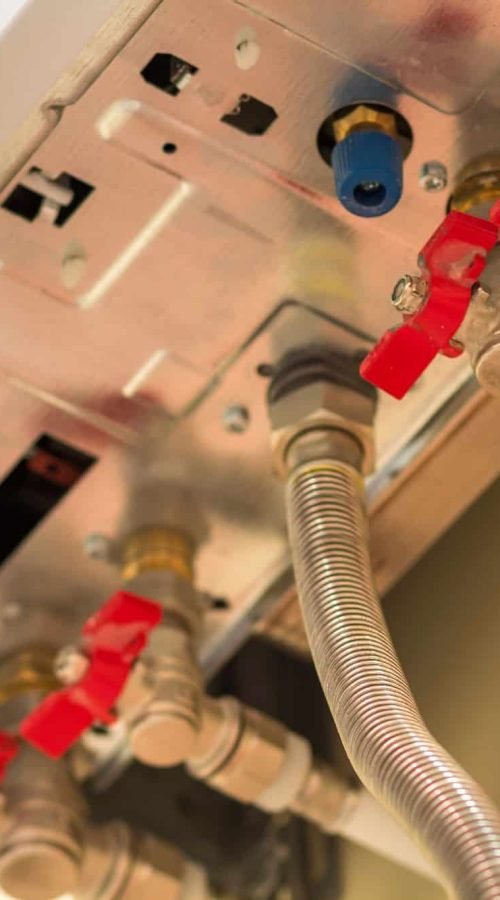 Gros plan sur les raccordements et vannes de chaudière à Caen pour diagnostic gaz.